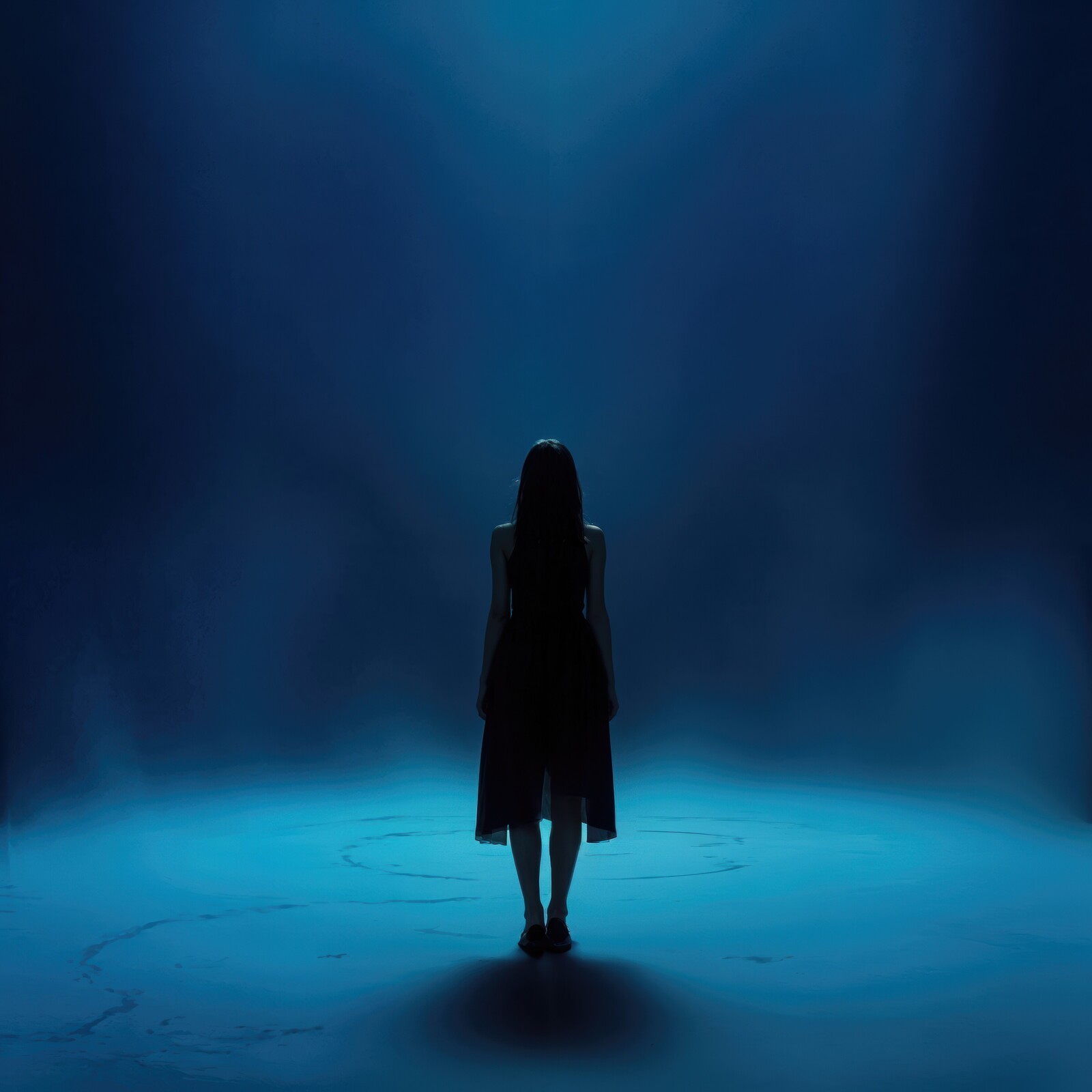 Silhouette of a solitary liminal figure immersed in blue mist during an ethereal performance at night